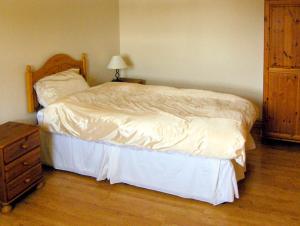a bedroom with a bed and a dresser and a night stand at Nuffies Cottage in Elton