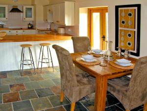 a kitchen with a wooden table with chairs and a counter at Howle Hideaway in Walford