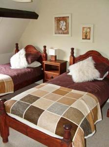 ein Schlafzimmer mit 2 Betten und einem Tisch mit einem Nachttisch in der Unterkunft 1 The Old Methodist Chapel in Rosedale Abbey