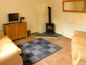 a living room with a checkered floor with a fireplace at Dairy Apartment 1 in Mere