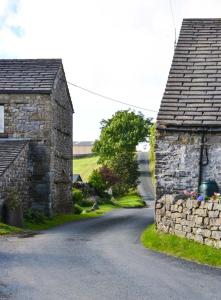 a road between two stone buildings on a street at Fawber Cottage in Horton in Ribblesdale