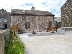 una casa de piedra con un patio frente a ella en Fell View Cottage en Bootle