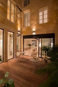 - une terrasse en bois avec des chaises et une table dans un bâtiment dans l'établissement Hôtel La Cour Carrée Bordeaux Centre, à Bordeaux