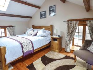 1 dormitorio con 1 cama, 1 silla y ventanas en Fell View Cottage en Bootle