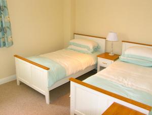 ein Schlafzimmer mit 2 Betten und einer Lampe auf einem Tisch in der Unterkunft Dairy Apartment 1 in Mere