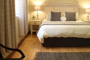 una camera con un grande letto e una sedia di Ripple Hill Hotel a Patensie