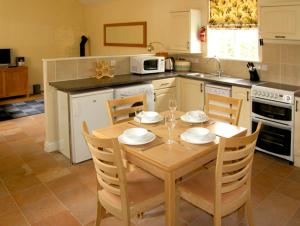 a kitchen with a wooden table with chairs and a dining room at Dairy Apartment 1 in Mere