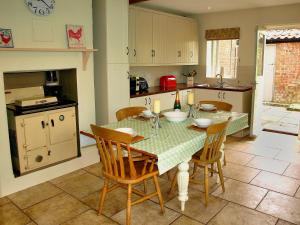 a kitchen with a table and chairs in a kitchen at Beaconsfield Cottage in Briston