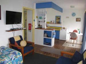 King Island Accommodation Cottages في Naracoopa: غرفة مع مطبخ وغرفة معيشة