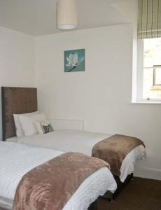 a bedroom with two beds and a window at No 5 The Stables in Pateley Bridge