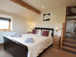 a bedroom with a large bed with two towels on it at Stoneycroft Barn in Langsett