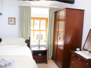 a bedroom with a bed and a cabinet and a window at Undercragg in Seathwaite