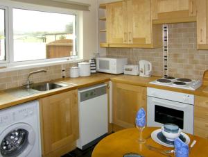 a kitchen with a sink and a dishwasher at 1 Mirehouse Place in Angle