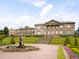 a large building with a fountain in front of it at Dairy Apartment 2 in Knutsford