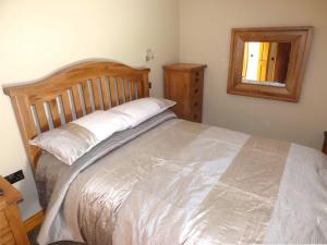 a bedroom with a large bed and a mirror at Corner Croft in Earl Sterndale