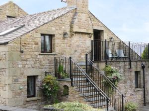 an old stone house with a spiral staircase at Hazelwood Cottage in Ingleton