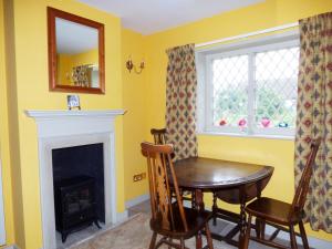 a dining room with a table and a fireplace at Shortmead Cottage in Biggleswade