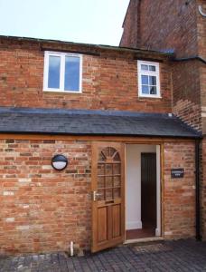 a brick building with a door in front of it at Cotswold View in Shottery