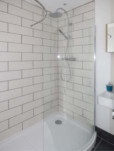 una doccia con una porta in vetro in un bagno di White Cottage Annexe a Tenby