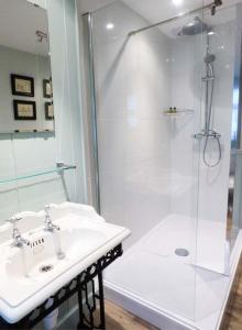 a white bathroom with a shower and a sink at Clock View in Haworth