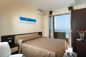 a bedroom with a bed and a large window at Casa Vacanze Samira in Fondachello