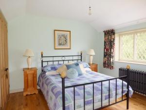 een slaapkamer met een bed, 2 lampen en een raam bij Shortmead Cottage in Biggleswade