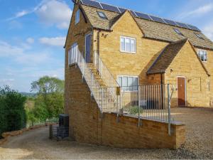 un edificio de ladrillo con una escalera en su lateral en Beautiful Cotswold View, en Bourton on the Water