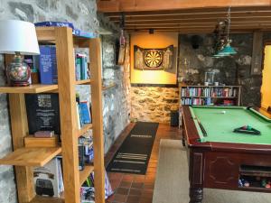 a room with a pool table and a book shelf at Bod Rhiw in Llandegwning