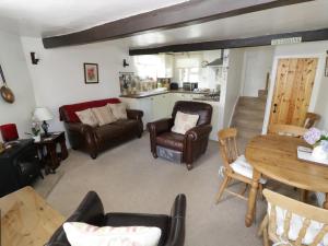 a living room with leather chairs and a table at Black Horse Cottage in Settle