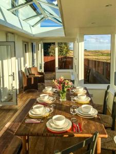 une table en bois avec des assiettes et des verres à vin dessus dans l'établissement Wold Cottage, à Hunmanby