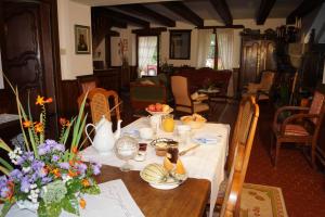 a dining table with a white table cloth and flowers on it at Le Moulin du Bignon in Lassy