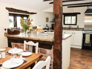 a kitchen with a wooden table with white chairs at 7 Gretton in Cardington