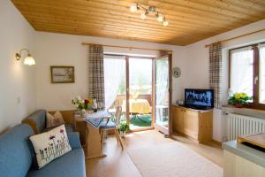 a living room with a blue couch and a television at Haus Christl Reit im Winkl, Kostenloser Parkplatz, Spülmaschine, 5 Minuten zum Ortszentrum, ruhige Lage, Wlan in Reit im Winkl