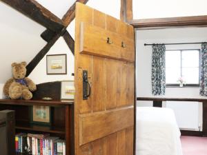 a door leading into a bedroom with a bed and a teddy bear at 7 Gretton in Cardington