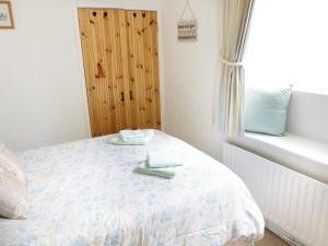 a bedroom with a bed with two towels on it at Black Horse Cottage in Settle