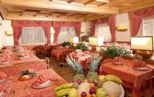 a dining room with tables with fruit on them at Hotel Europa in Moena
