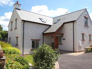 una casa blanca con techo de gambrel en Margaret House en Pooley Bridge