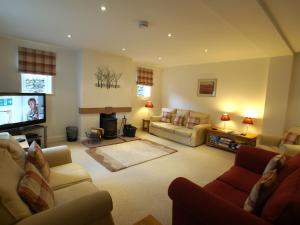 a living room with couches and a flat screen tv at Margaret House in Pooley Bridge