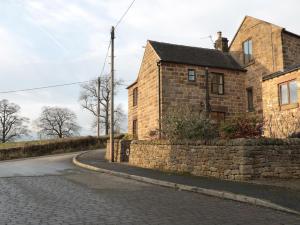 an old stone house on the side of a road at Netherlea Cottage in Highpeak Junction