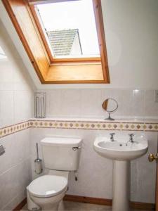 a bathroom with a toilet and a sink with a skylight at Stemster School House Apartment in Castletown