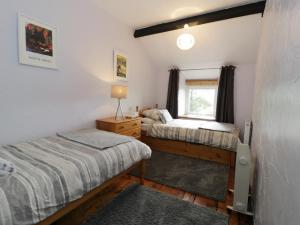1 dormitorio con 2 camas y ventana en Ty Cynon en Blaenau-Ffestiniog