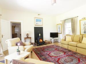 a living room with a couch and a fireplace at Bannatyne Lodge in Newtyle