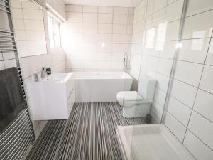 un bagno bianco con vasca e WC di Little Orme View a Llandudno Altre 25 foto