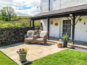 two chairs on a patio outside of a house at Saetr Cottage in Harrop Fold