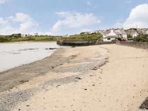 a sandy beach next to a body of water at The Studio The Old Post Office in Cemaes Bay