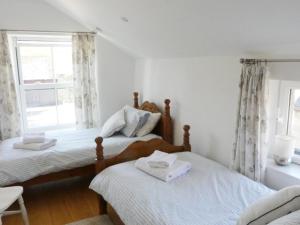 a bedroom with two beds and a window at Old Farm House in Great Rowsley