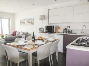 a kitchen and dining room with a table and chairs at Harbourside House in Haverigg