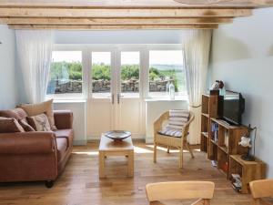 ein Wohnzimmer mit Sofa und Fernseher in der Unterkunft Field Cottage in Loftus