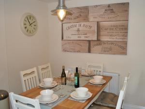 a dining room table with chairs and a clock on the wall at 4 The Old Smithy in Freshwater
