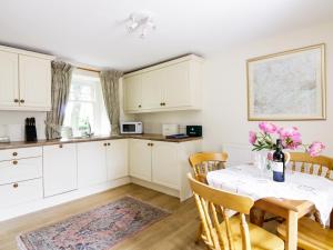 a kitchen with a table with a vase of flowers on it at Bannatyne Lodge in Newtyle